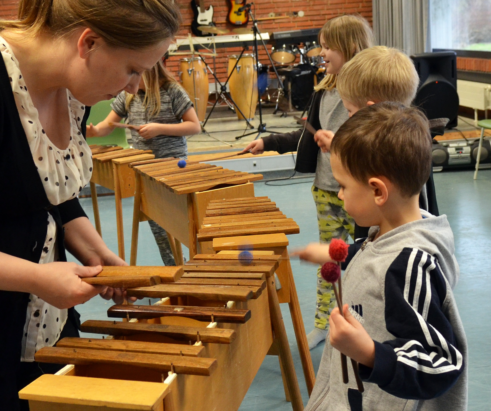 Lærer hjælper dreng med indstilling af xylofonen