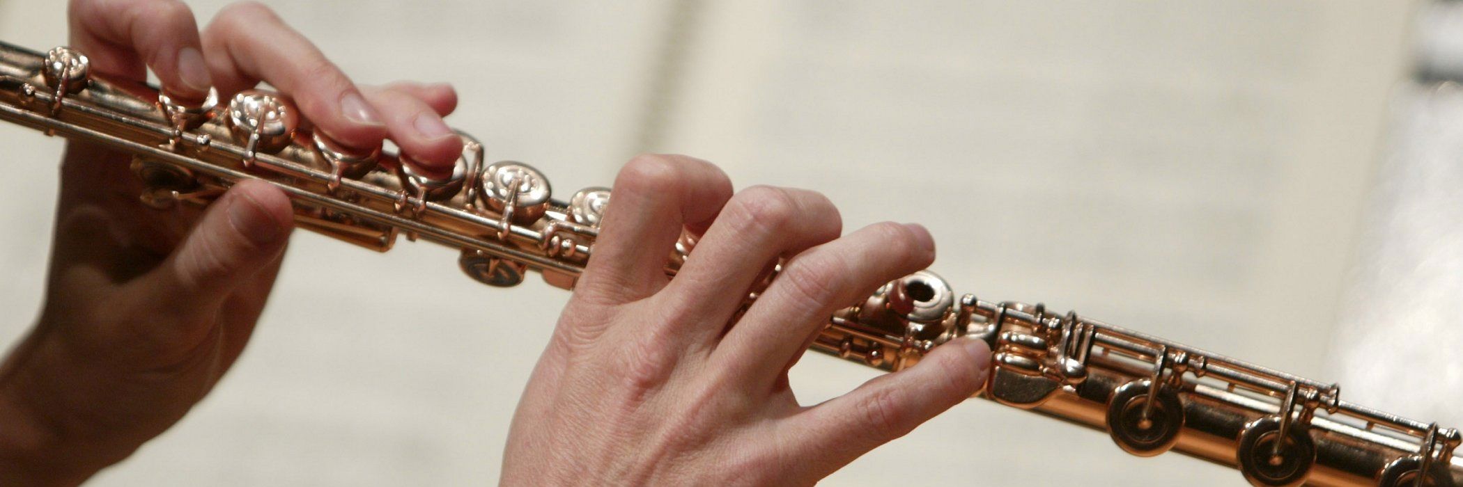 Hænder på tværfløjte foran noder